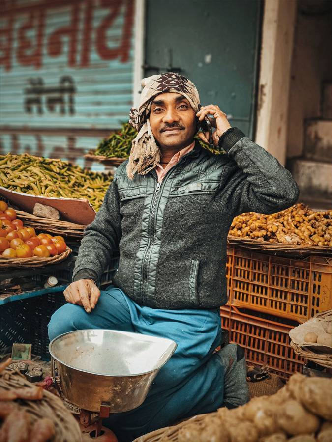 Vegetable vendor on his phone